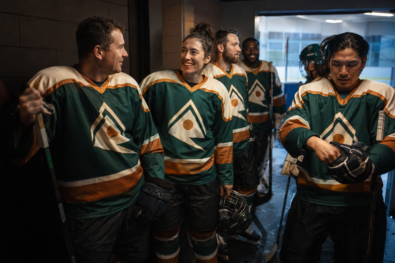 Hockey teammates in matching custom jerseys sharing a laugh in the locker room hallway