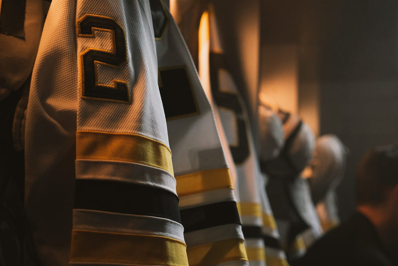 Close-up of a custom sublimated hockey jersey number and sleeve in the locker room