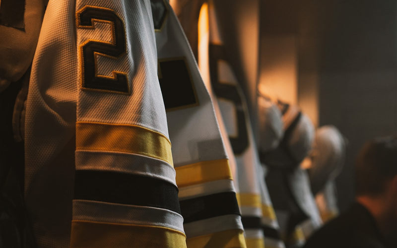 Close-up of a custom sublimated hockey jersey number and sleeve in the locker room
